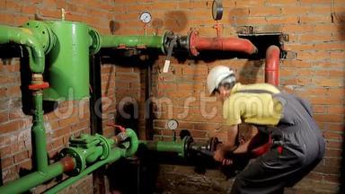 一名穿工作服的工人<strong>打开水</strong>阀.. 这个人包括锅炉房的暖气。